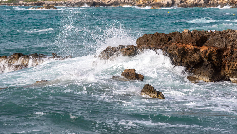Waves splashing on rocks in sea