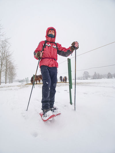 Full length of man skiing on snowy field against sky