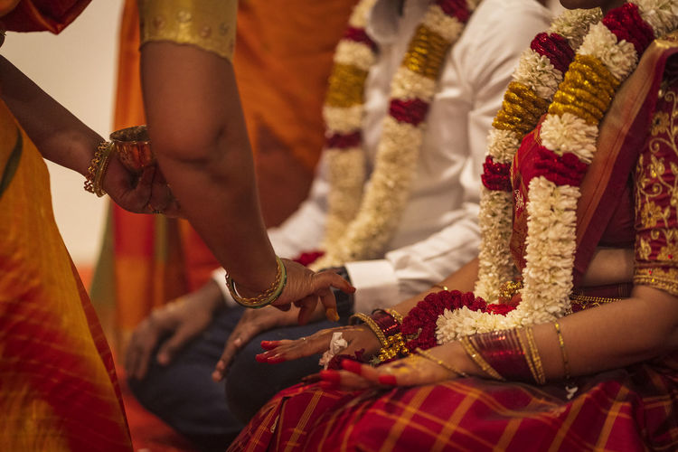 Woman by bride and bridegroom during wedding ceremony