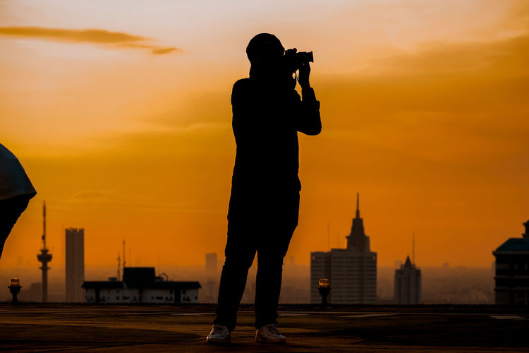 Silhouette man standing against sky during sunset in jakarta 