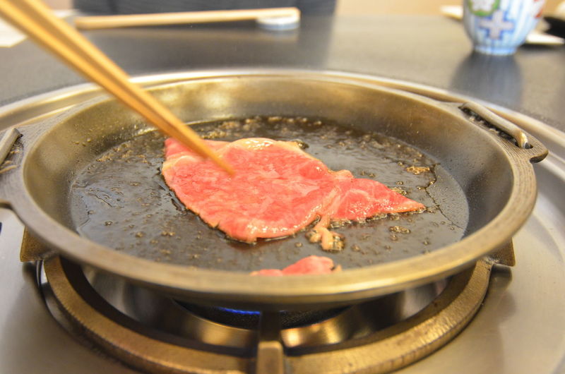 Preparation of sukiyaki in pan on gas stove