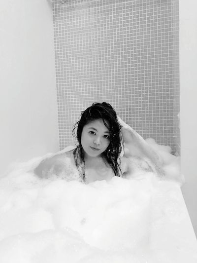 Portrait of topless woman bathing in bathtub
