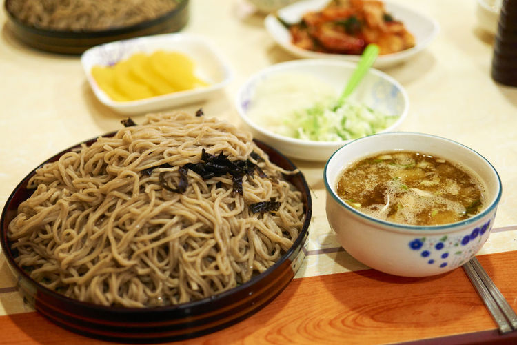 High angle view of noodles and soup served on table
