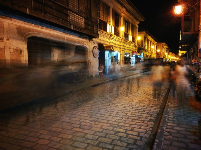 People walking on sidewalk at night