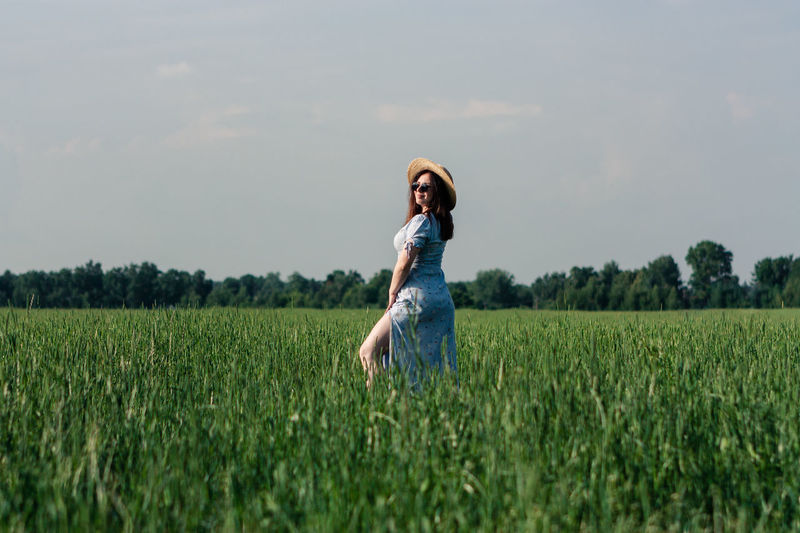 Woman in hat in the green field