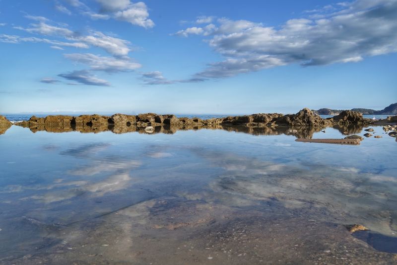 Panoramic view of rocks on shore against sky