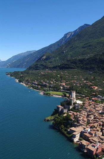 High angle view of townscape by sea against clear sky