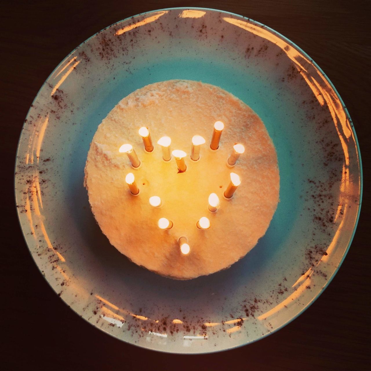 HIGH ANGLE VIEW OF ILLUMINATED CANDLE ON TABLE