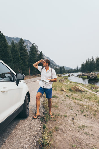 Young man having a problem with orientation on the road during his journey with a car.