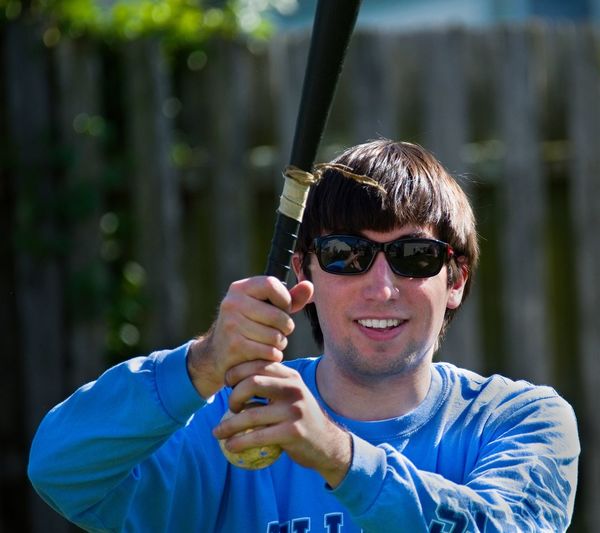 Portrait of smiling man holding baseball bat