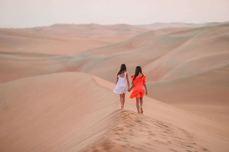 Rear view of women standing in desert