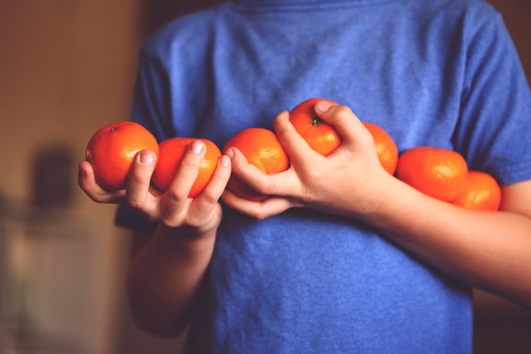 Close-up of hands holding oranges