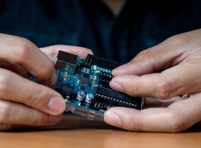 Midsection of man repairing computer chip