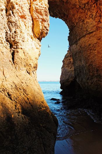 Rock formations by sea against sky