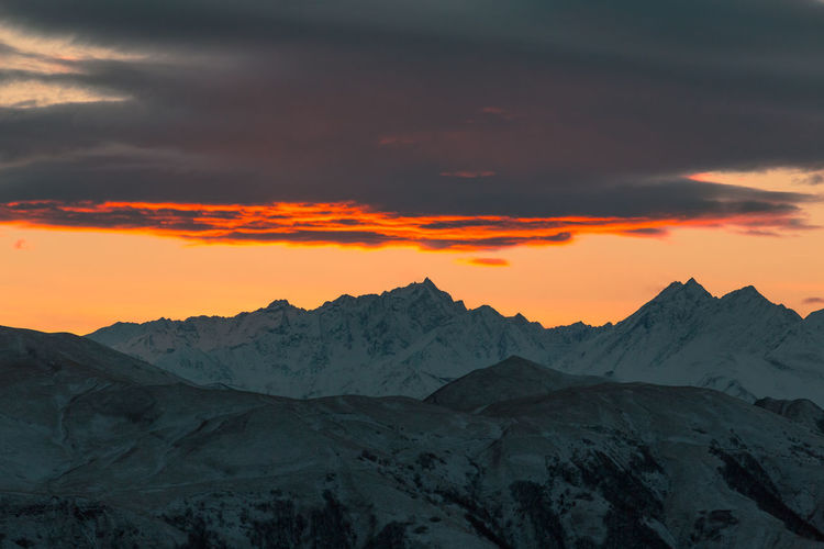 Scenic view of snowcapped mountains against sky during sunset