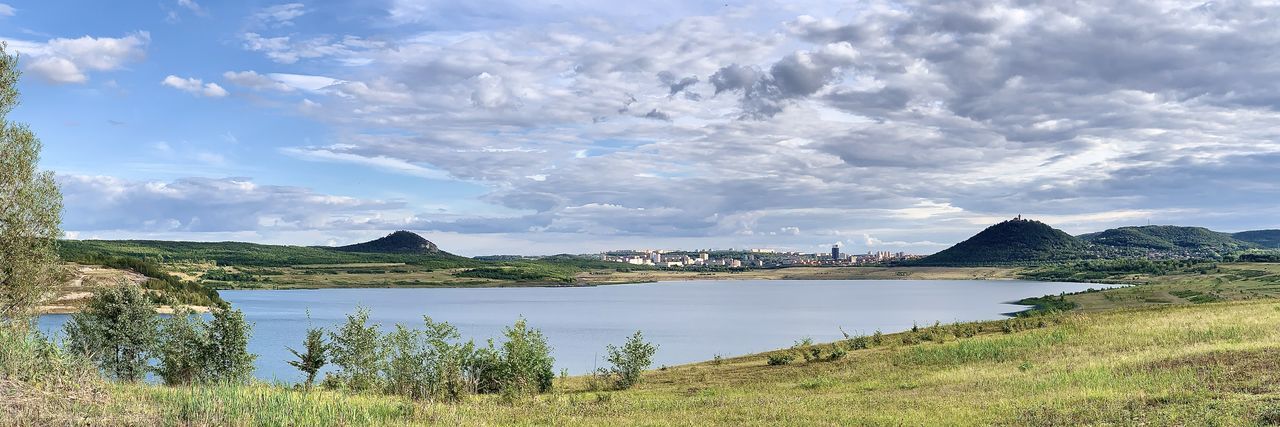 Scenic view of lake against city.