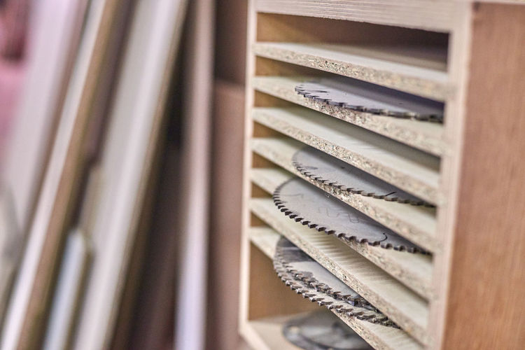 Close-up of saws on shelves in workshop
