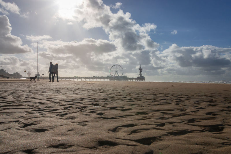 Low angle view scheveningen beach with blurred pier and ferris wheel in the background