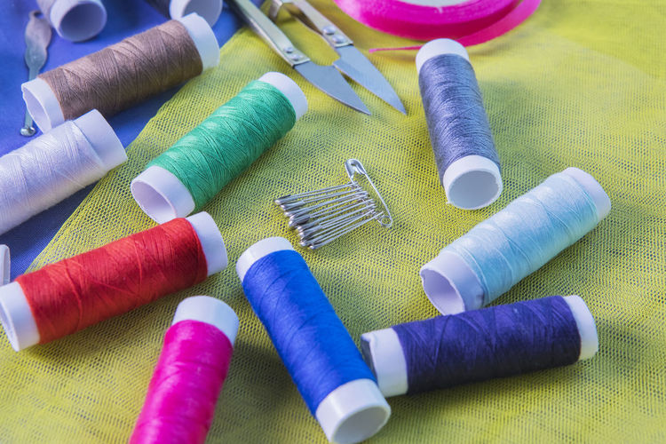 High angle view of colorful sewing items on fabric