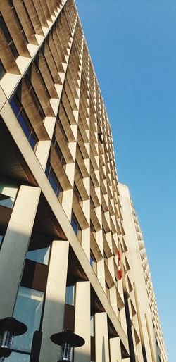 Low angle view of modern building against clear blue sky