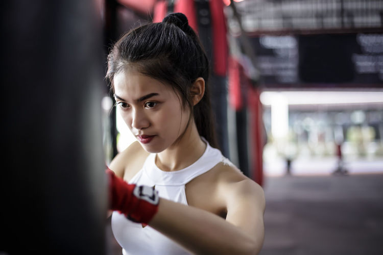 Young woman looking away while practicing boxing