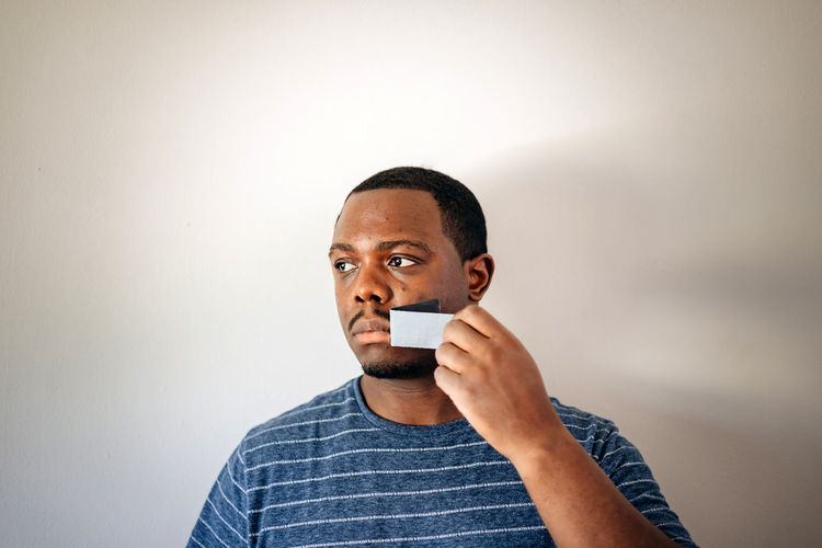 Silence or free speech concept, african american or black man with tape on mouth