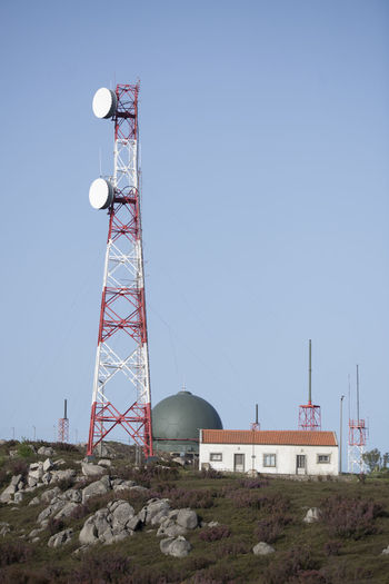 Low angle view of communications tower against clear sky during sunny day