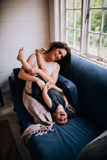 Cuddle Family Happiness Happy People Home Laughing Moments Mother Quality Time Boy Cabin Child Emotion Front View Happiness Indoors Lifestyles Mom Real People Sitting Smile Smiling Toddler Togetherness Young Adult