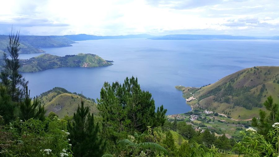 Scenic view of sea and mountains against sky