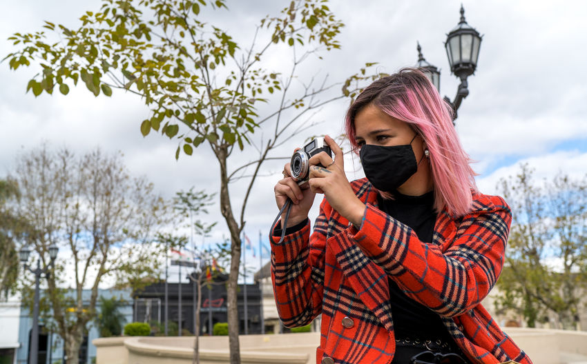 Young tourist woman with camera taking photos