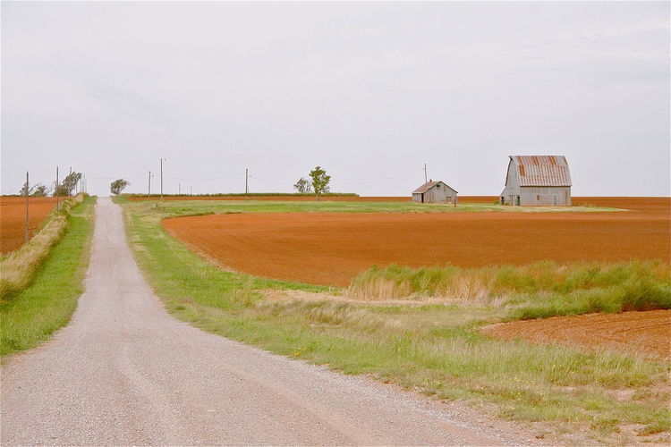 Road in field against clear sky