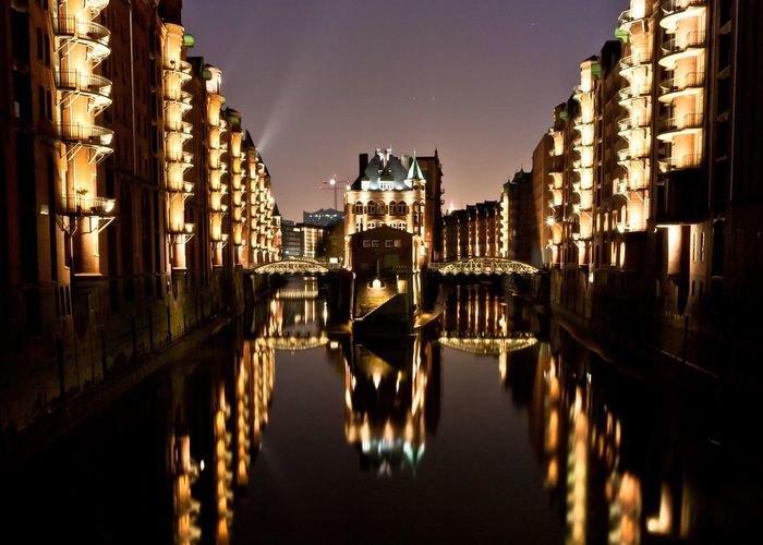 Illuminated buildings reflection in speicherstadt at night