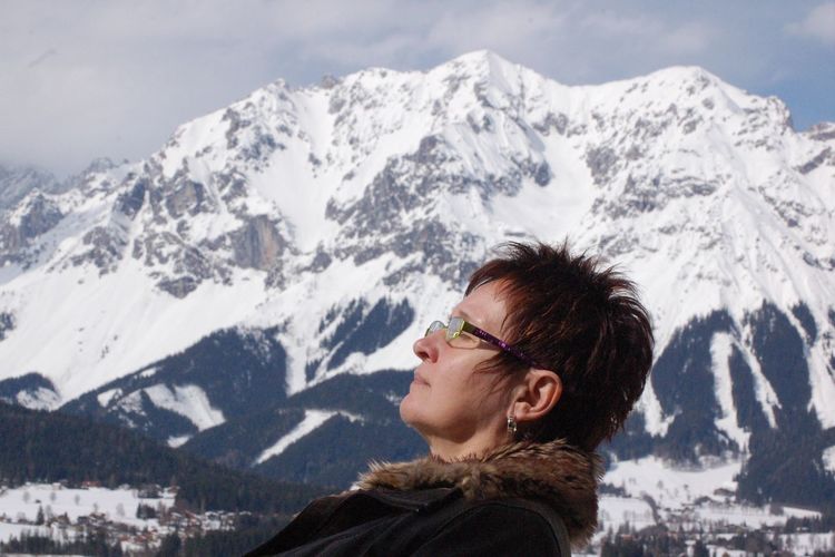 Side view of woman against snowcapped mountain