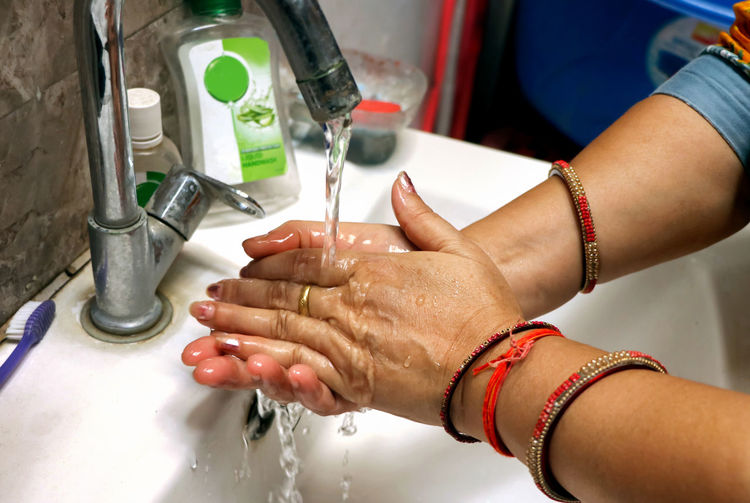 Cropped hands of man repairing faucet