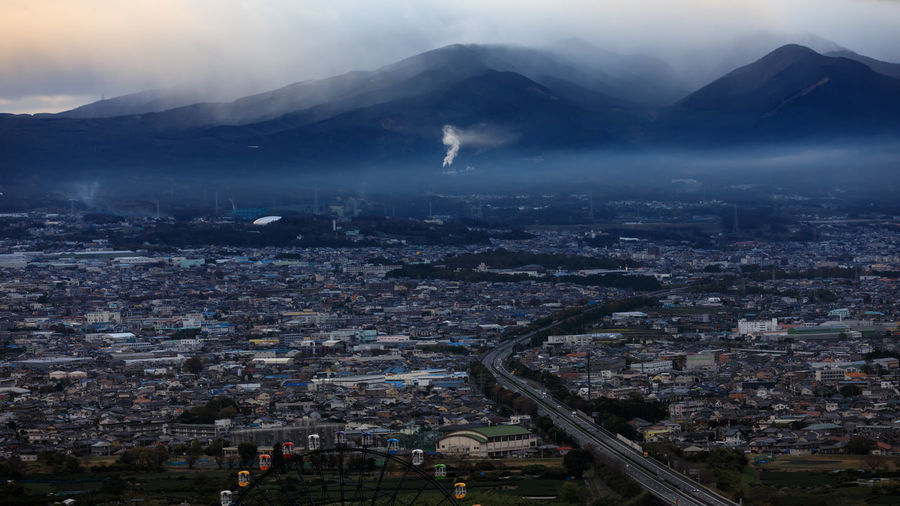Dramatic and dark process cityscape in a strom and smog layer mountain background in japan