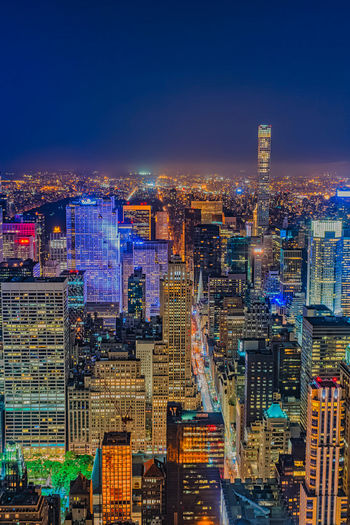 Illuminated buildings in city against sky at night
