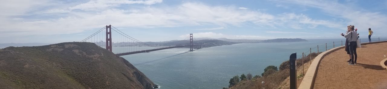 Panoramic view of suspension bridge over sea against sky