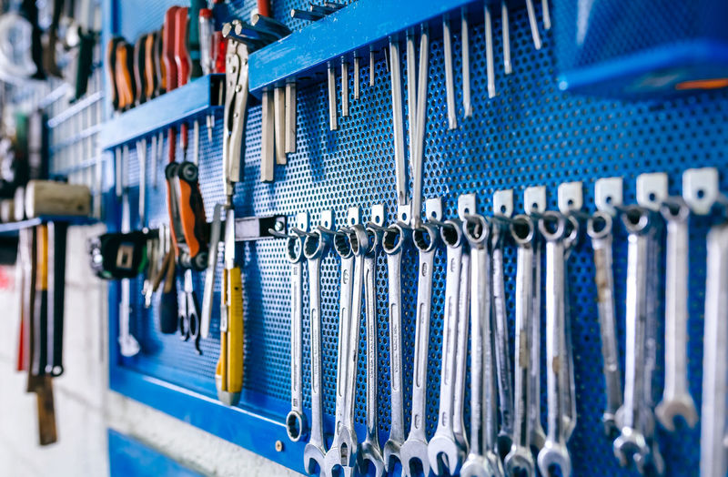 Close-up of work tools hanging on peg board in workshop