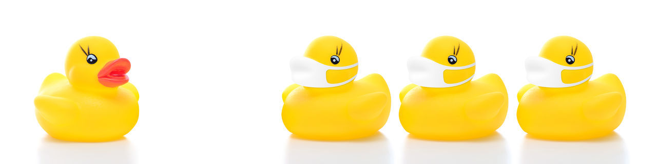 Close-up of yellow toys over white background