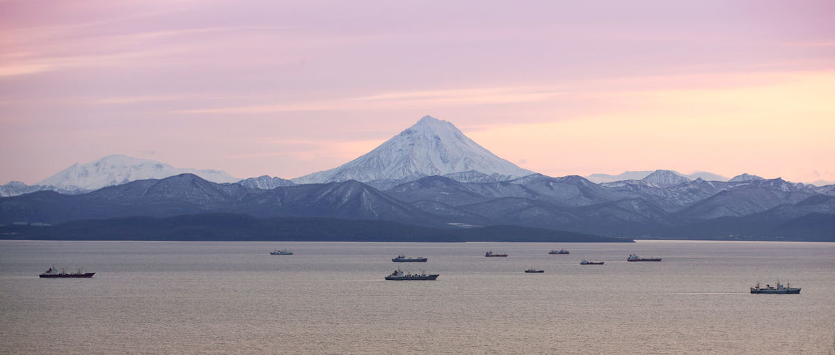 The fishing boats in the bay with the volcano on kamchatka
