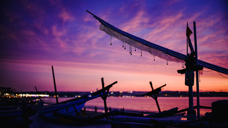Silhouette of sailboats in sea at sunset