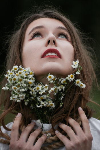 Close-up portrait of a beautiful young woman holding flower