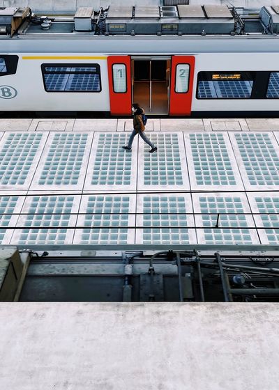 High angle view of woman walking on railroad station platform