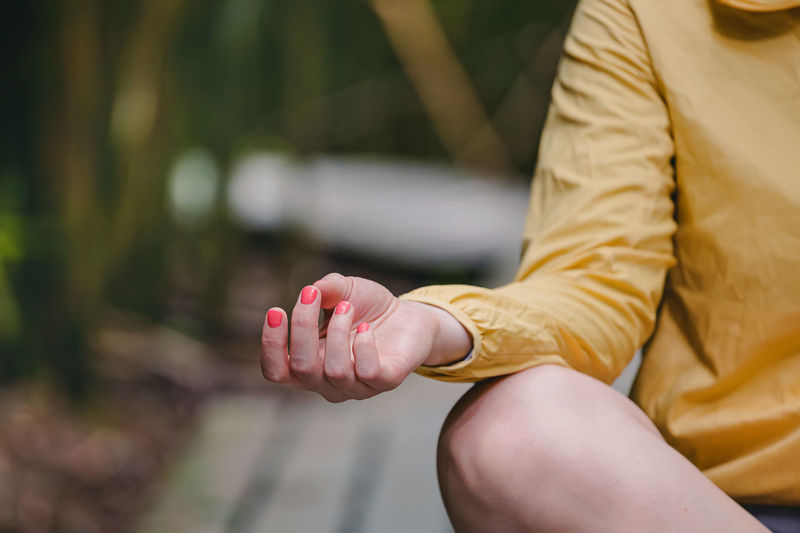 Meditation in the park, close-up of woman's hand, lotus pose