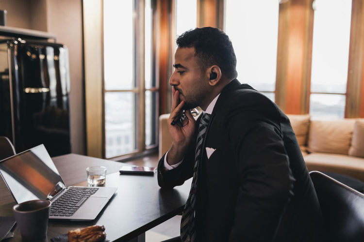 Worried businessman looking at laptop in board room