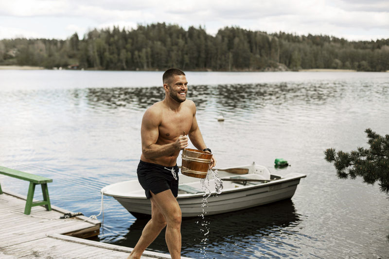 Portrait of shirtless man swimming in lake