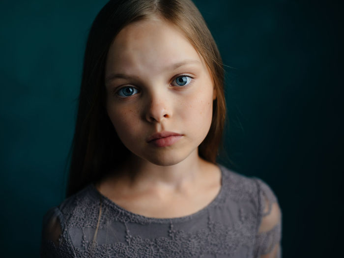 Close-up portrait of girl over black background