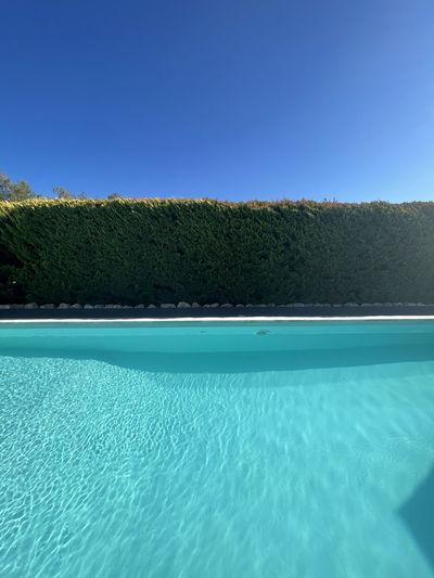 Scenic view of swimming pool against clear blue sky