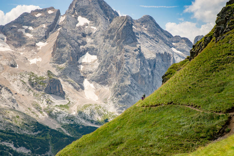 Man and woman riding their mountain bikes on footpath in the scenic dolomites, italy