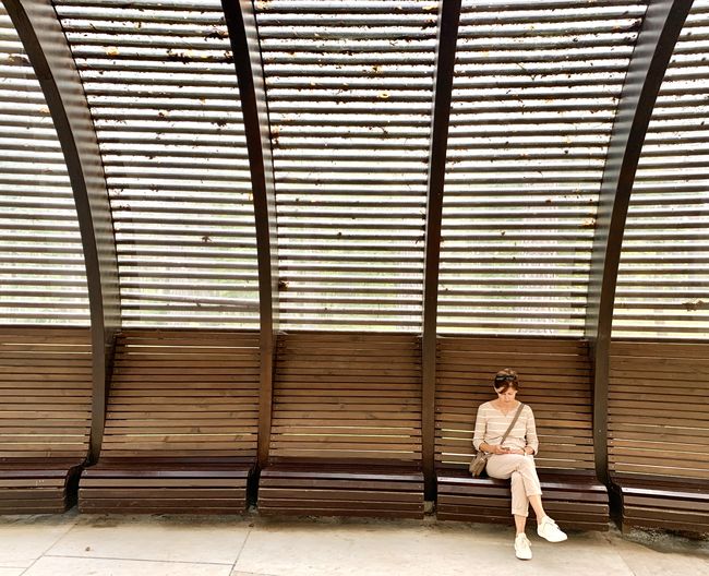 Lonely woman sitting on the bench outdoors